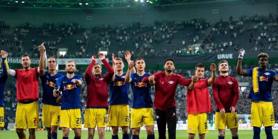 Die RB-Spieler feiern vor ihren Fans den Sieg in Gladbach. Foto: Marius Becker