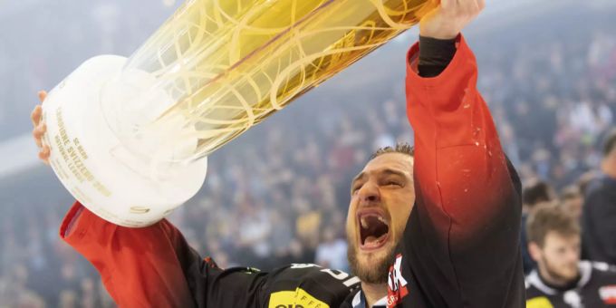 SCB-Spieler Tristan Scherwey jublet mit dem Meisterpokal. Tristan Scherwey SCB
