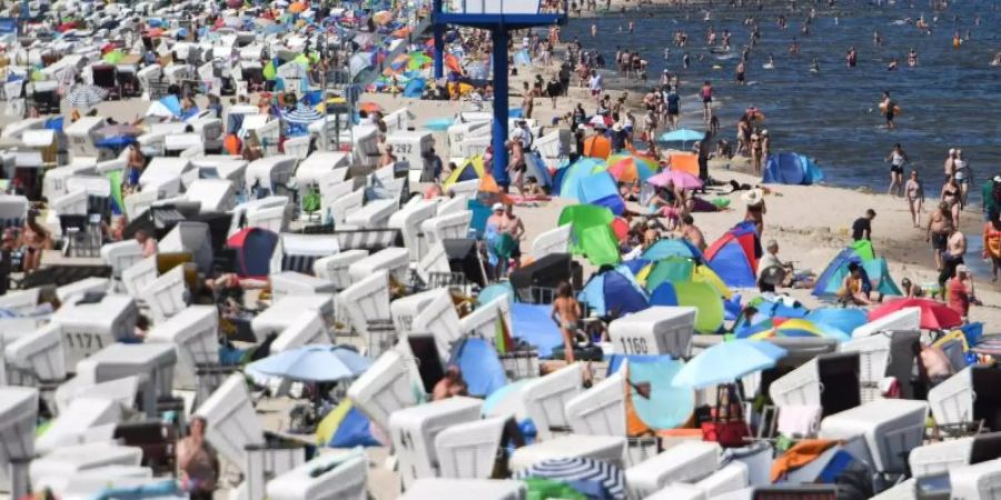 Hunderte Touristen besuchen einen Strand an der Ostsee auf der Insel Usedom. Foto: Stefan Sauer/Illustration