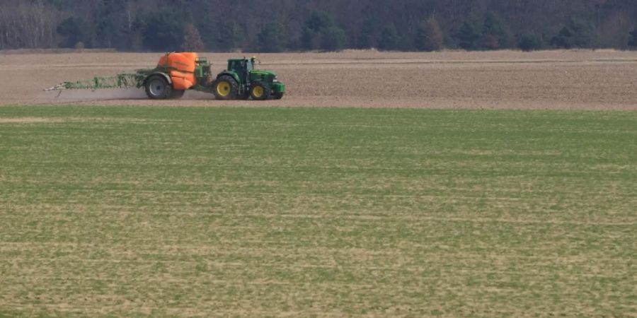 Dünger wird auf einer Ackerfläche ausgebracht