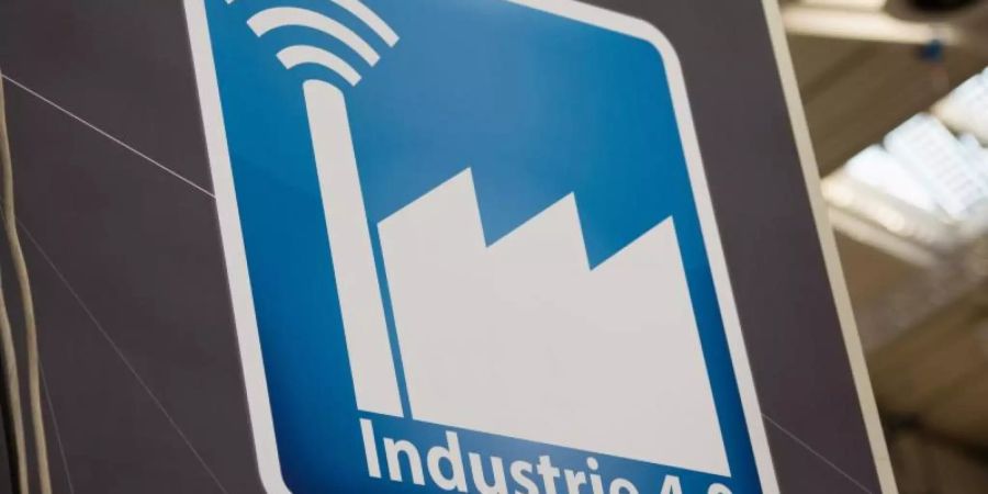 Piktogramm mit der Aufschrift «Industrie 4.0». Zwei Drittel (65 Prozent) der Unternehmen ab 20 Mitarbeitern aus allen Branchen berichten, dass IT- und Internet-Firmen in ihren Markt drängen. Foto: Christophe Gateau