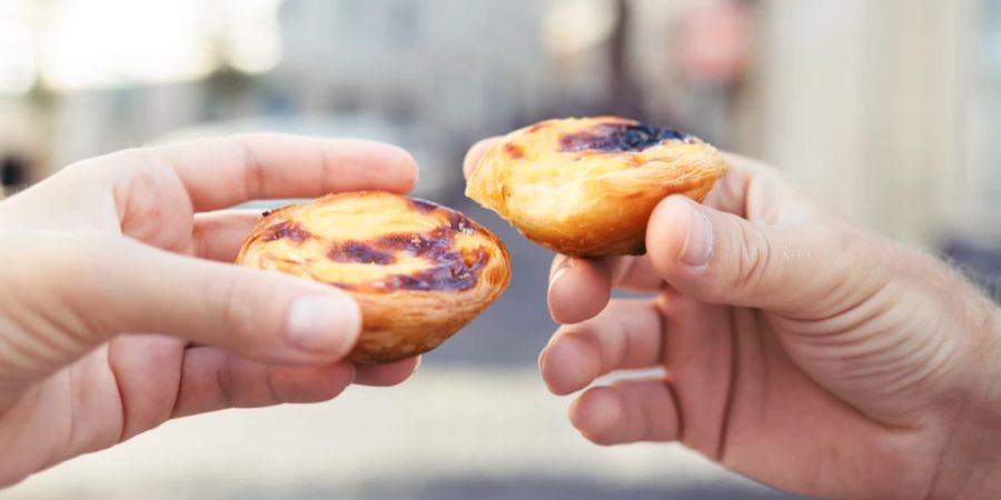 Zwei Pastel de Nata zwei Hände