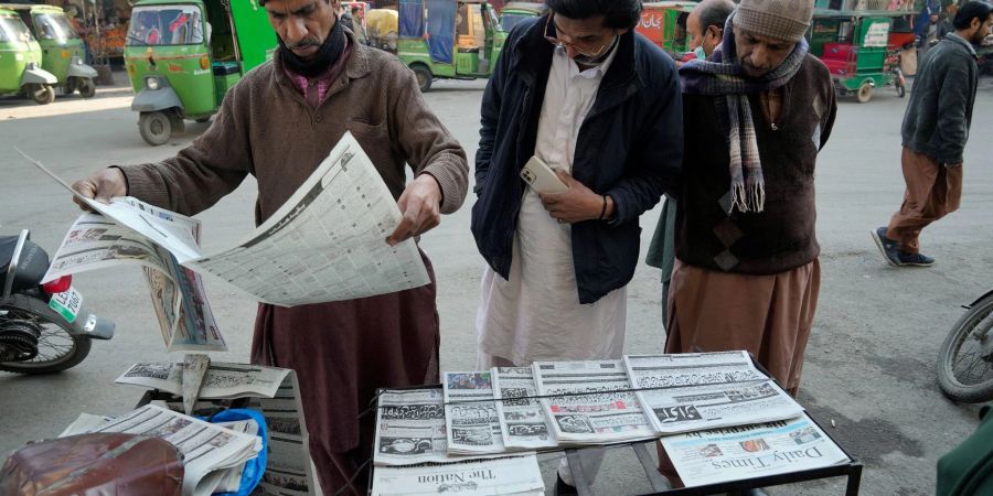 Menschen lesen an einem Stand in Lahore die Morgenzeitung. Pakistans Wahlen waren überschattet von Internetsperren und Manipulationsvorwürfen.