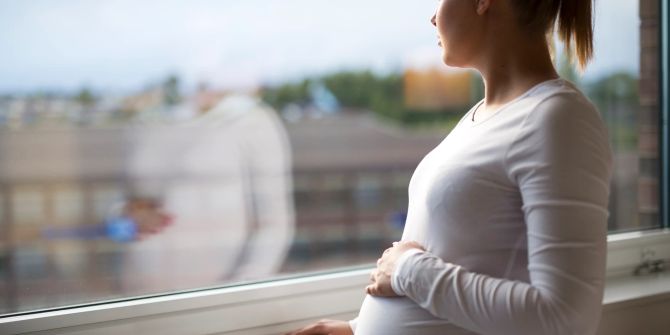 Nachdenkliche Schwangere am Fenster