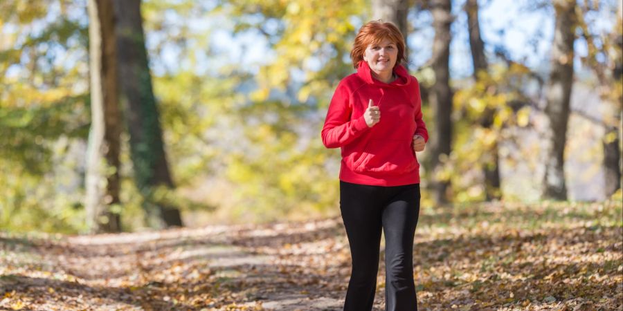 Ältere Frau joggt im Park