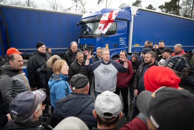 Edwin Atema (M), niederländischer Gewerkschafter des FNV und dem Road Transport Due Diligence Team (RTDD), spricht nach einem Polizeieinsatz auf der Raststätte Gräfenhausen zu Lkw-Fahrern. LKw fahrer