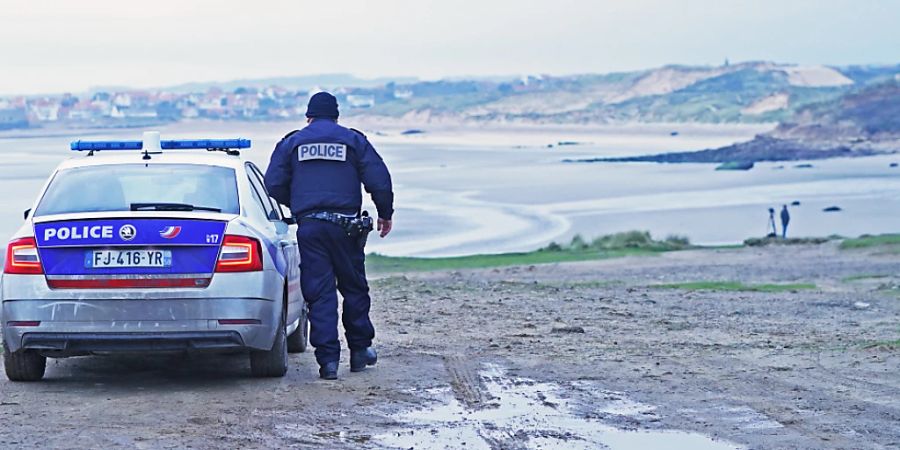 ARCHIV - Ein französischer Polizist blickt über die Küste bei Wimereux, nördlich von Boulogne in Nordfrankreich. Foto: Stefan Rousseau/PA Wire/dpa