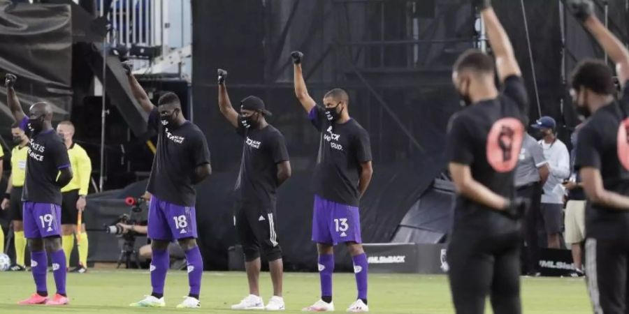 Orlando-Spieler heben vor dem Spiel ihre Fäuste als Zeichen gegen Rassismus. Foto: John Raoux/AP/dpa