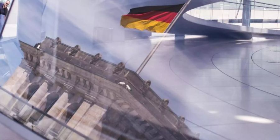 Deutschland-Fahne spiegelt sich in der Kuppel des Reichstagsgebäudes
