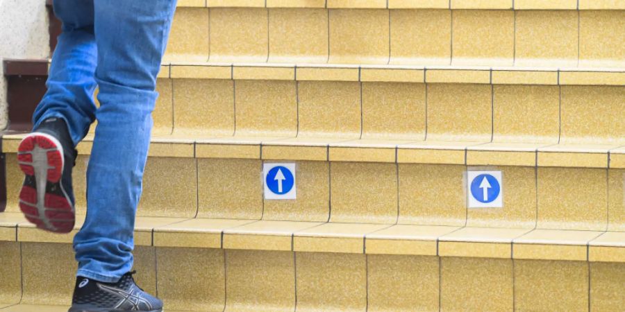 Ein Schüler geht während der Wiedereröffnung einer Sekundärschule in Brüssel eine Treppe mit Markierungen hinauf. Foto: Laurie Dieffembacq/BELGA/dpa