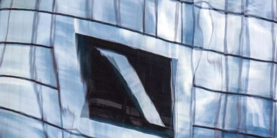 Die Zentrale der Deutschen Bank in Frankfurt am Main spiegelt sich in einer Glasfassade. Foto: Boris Roessler/dpa