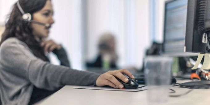 Eine Frau telefoniert mit einem Headset. (Symbolbild) Banken rüsten Callcenter auf