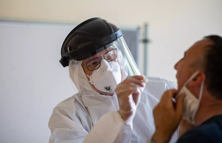 Ein Arzt in Gütersloh führt bei einem Mann ein gratis Coronavirus-Test durch.