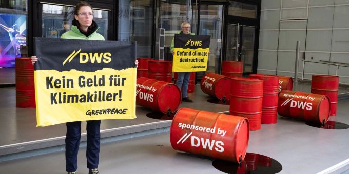 Mit roten Ölfässern protestieren Aktivisten von Greenpeace vor der Zentrale von DWS Investment in Frankfurt gegen die Investitionspolitik des Fonds. DWS