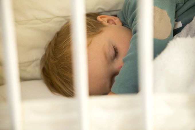 Erholsamer Schlaf – der ist für Kinder mit Neurodermitis und ihre Eltern oft nicht möglich. Kind Kinderbett Schlaf Decke