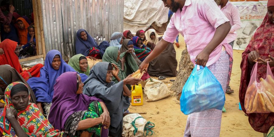 An Somalier, die vor der Dürre geflohen sind, werden am Rande der Hauptstadt Mogadischu Lebensmittelspenden verteilt.