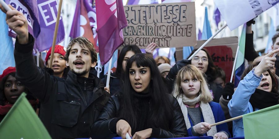 Demonstranten schwenken Fahnen während einer Kundgebung in Paris, zu der die linke Partei La France Insoumise und Jugendorganisationen aufgerufen haben, um gegen die Rentenreform des französischen Präsidenten zu protestieren. Foto: Lewis Joly/AP/dpa