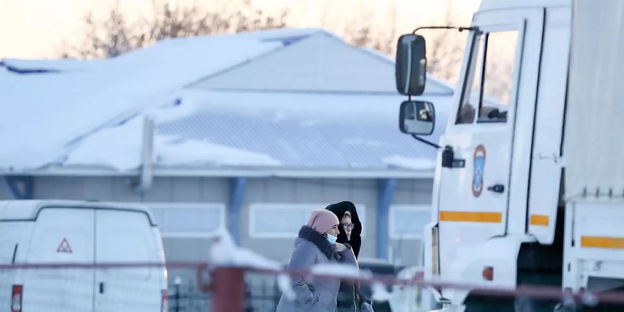 Angehörige der Opfer gehen vor dem Kohlebergwerk «Listwjaschnaja» in der Stadt Belowo im Südwesten Sibiriens. Nach dem schwersten Grubenunglück in Russland seit Jahren mit mindestens 52 Toten wollen die Rettungskräfte die Suche nach den verunglückten Bergleuten fortsetzen. Foto: Maxim Kiselev/TASS/dpa