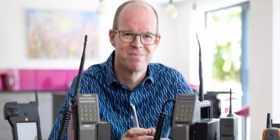Ben Wood, Gründer des Museums, sitzt hinter einigen der über 2.000 einzigartigen Mobiltelefone, die jetzt Teil des Online-Museums sind. Foto: Mobile Phone Museum/Vodafone/PA Media/dpa/Archiv