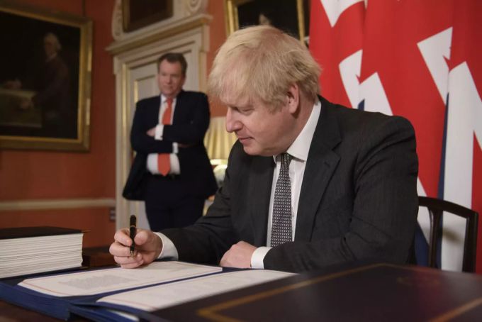 Boris Johnson unterzeichnet das Freihandelsabkommen mit der EU, im Hintergrund David Frost, der dieses ausgehandelt hat. Johnson