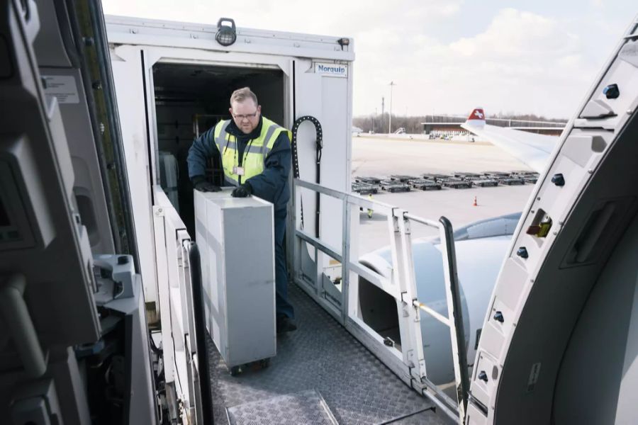 Ein Mitarbeiter von Gate Gourmet transportiert Essen zu einem Swiss-Flugzeug.