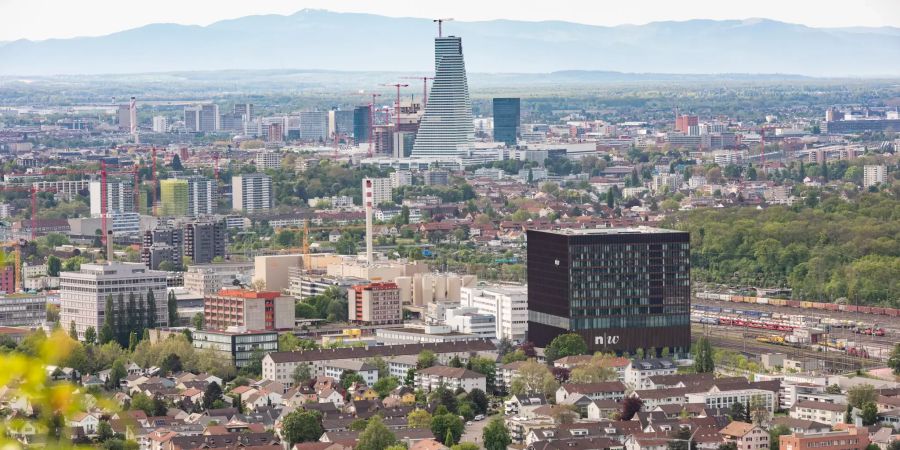 Die Gemeinde Muttenz aus der Vogelperspektive mit der Stadt Basel im Hintergrund.