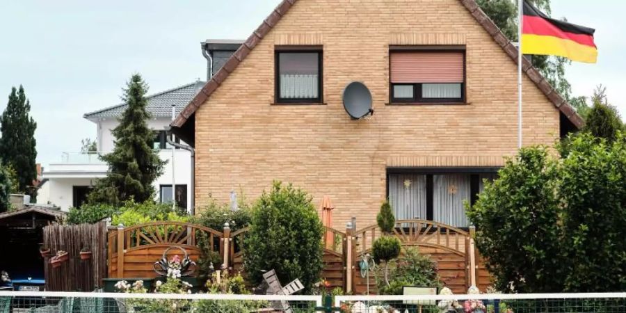 Eine Deutschlandfahne weht vor einem Einfamilienhaus. Die Mittelschicht in Deutschland ist laut einer neuen Studie erheblich kleiner als noch Mitte der 1990er Jahre. Foto: Stefan Jaitner/dpa