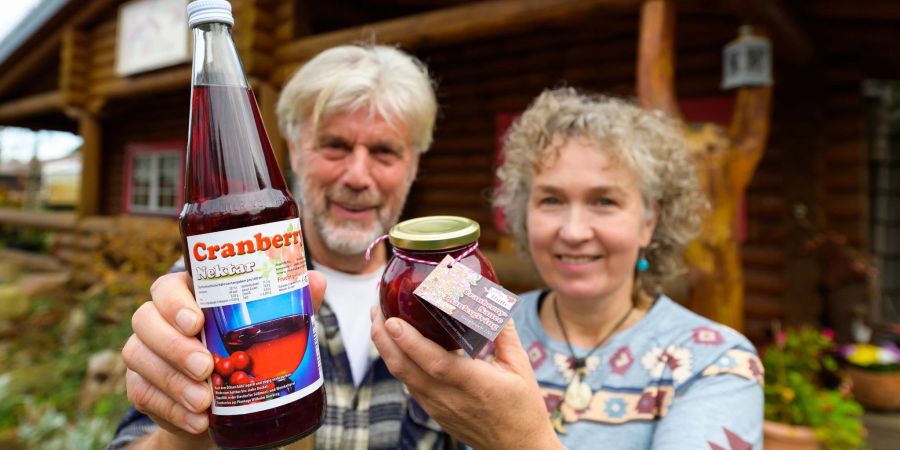 Wilhelm und Sonja Dierking halten Cranberrysaft aus der eigenen Ernte in den Händen. In Deutschland gehört die Familie Dierking in der Lüneburger Heide zu den wenigen, die die Beeren aufwendig anbauen.