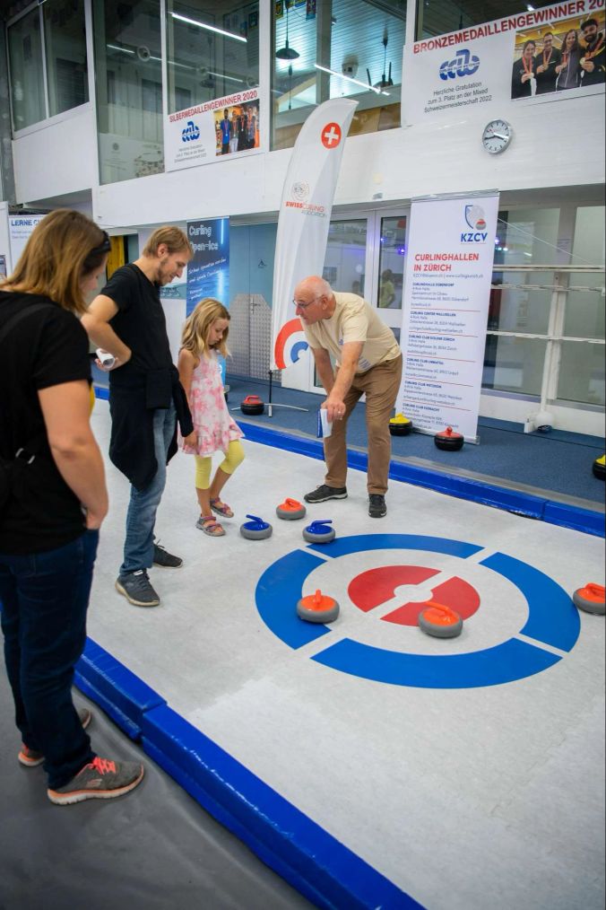 Die Messebesucher dürfen sich im Curling probieren.