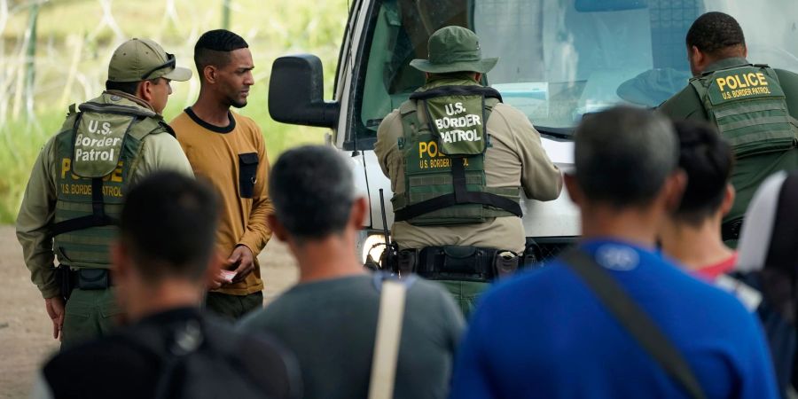 Aus Lateinamerika vertriebene Menschen werden in Texas von der Grenzpatrouille abgefertigt, nachdem sie illegal den Fluss Rio Grande von Mexiko in die USA überquert haben.