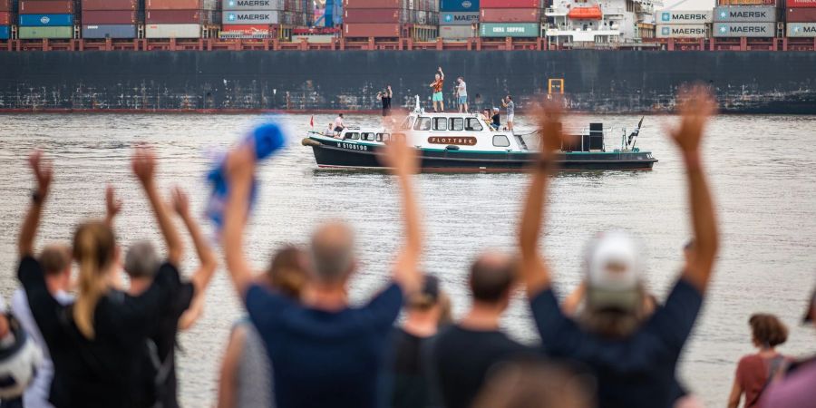 Die Band Fettes Brot tritt auf einem Boot auf der Elbe vor dem Elbstrand auf.