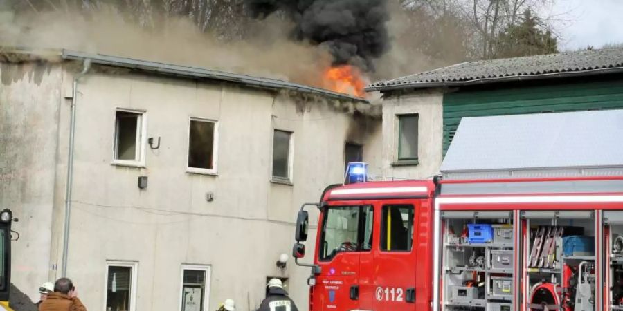 Ein Feuerwehrfahrzeug am Mittwoch vor dem brennenden Haus in Arnsberg. Foto: Wolfgang Becker