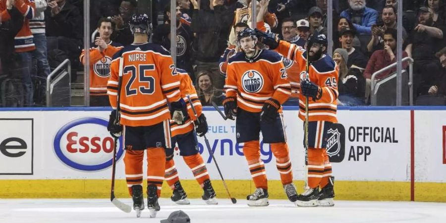 Leon Draisaitl (2.v.r) wird nach seinem dritten Tor von seinen Mitspielern und den Fans gefeiert. Foto: Jason Franson/The Canadian Press/AP