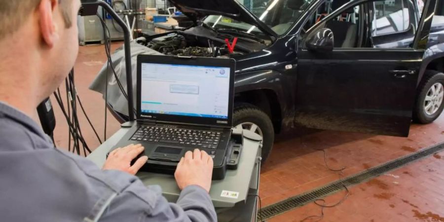 Ein Kfz-Mechaniker lädt ein Software-Update für ein Diesel-Fahrzeug hoch. Foto: Julian Stratenschulte