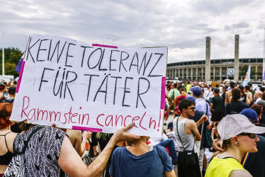 Personen demonstrieren vor dem Berliner Olympiastadion gegen den Auftritt von Rammstein.