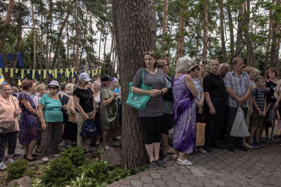 Menschen in der Ukraine warten in einer Schlange, um Nahrungsmittel zu bekommen. Viele sind auf Hilfsorganisationen angewiesen.