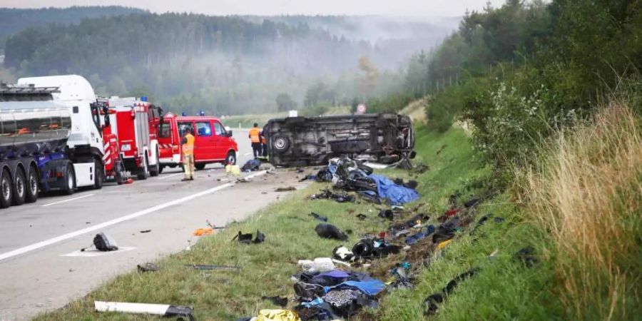 Trümmerteile liegen an der Unfallstelle neben der Autobahn 9, im Hintergrund liegt der umgestürzte Transporter. Foto: Bodo Schackow