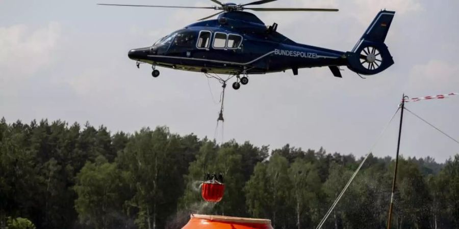 Ein Hubschrauber der Bundespolizei nimmt in Frankenförde Löschwasser auf. In Frankenförde bei Jüterbog befindet sich die Einsatzzentrale der Feuerwehr. Foto: Christoph Soeder