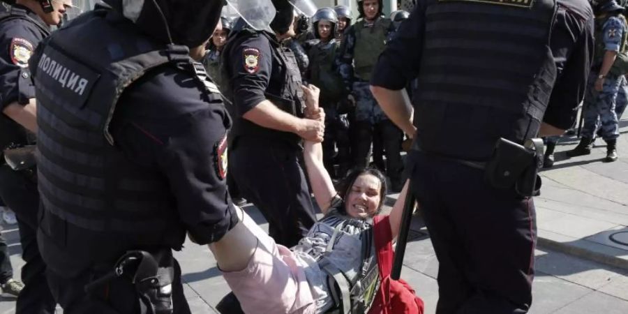 Im Zentrum Moskaus führen Polizisten eine Frau ab. Foto: Alexander Zemlianichenko/AP