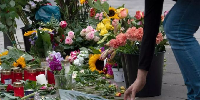 Eine Frau legt Blumen an der Stelle ab, an der vier Menschen bei einem Verkehrsunfall ihr Leben verloren. Foto: Paul Zinken berlin