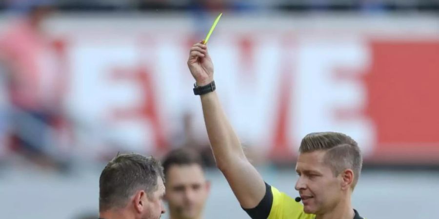 Schiedsrichter Tobias Welz (r) zeigt Paderborn-Trainer Baumgart (l) die erste Gelbe Karte. Foto: Friso Gentsch