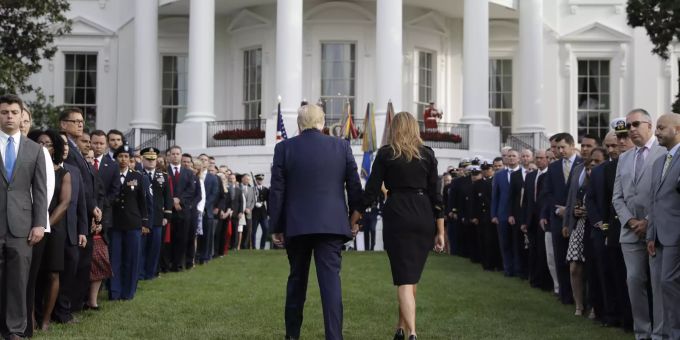 Präsident Donald Trump und First Lady Melania Trump gehen zurück, nachdem sie an einer Schweigeminute zu Ehren der Opfer der Terroranschläge vom 11. September auf dem Südrasen des Weißen Hauses in Washington teilgenommen haben. Terroranschläge am 11. September 2001