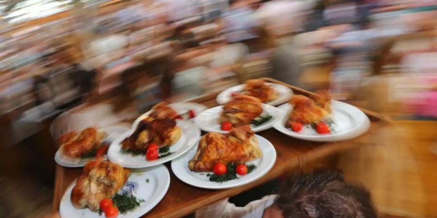 Diät geht anders: Kellner auf dem Oktoberfest mit einem Tablett Hendl (Hähnchen). Foto: Karl-Josef Hildenbrand