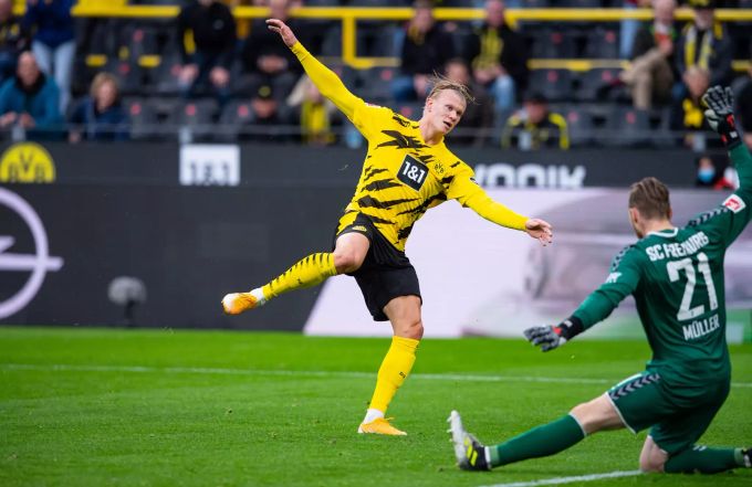 Erling Haaland (BVB) schiesst den Ball vorbei an Freiburg-Torhüter Florian Müller. BVB Freiburg Erling Haaland