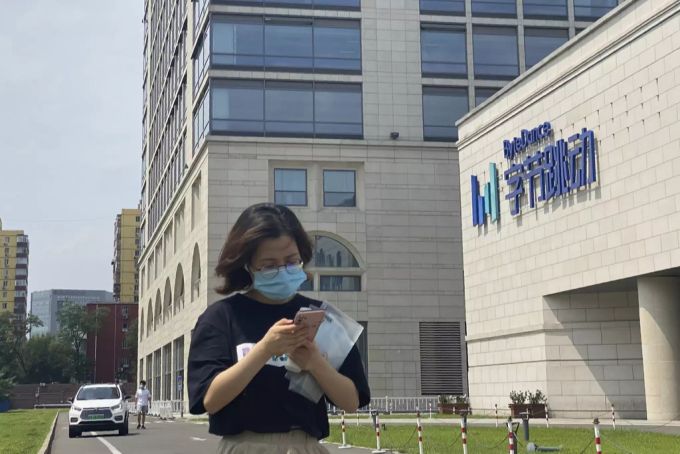 Eine Frau spaziert am Hauptsitz von ByteDance in Peking vorbei. Bytedance