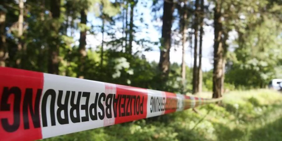 Ein Absperrband der Polizei umzäunt ein Waldstück an einer Verbindungsstrasse zwischen Rodacherbrunn in Thüringen und Nordhalben in Bayern. Foto: Bodo Schackow/ZB/dpa