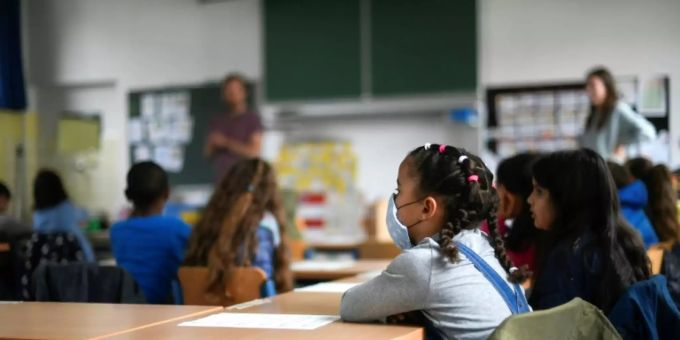 Schülerin mit Mundschutz in einem Klassenzimmer Schülerin mit Mundschutz in einem Klassenzimmer