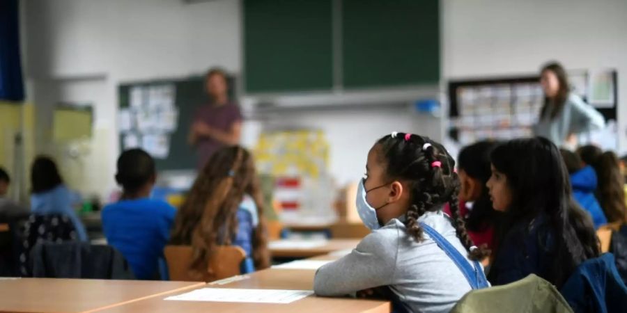 Schülerin mit Mundschutz in einem Klassenzimmer