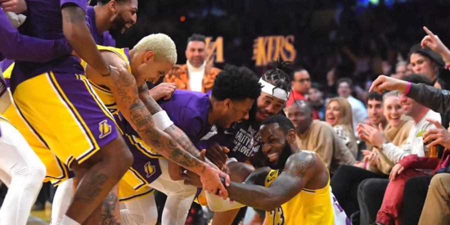 LeBron James (sitzend) wird nach mehreren erfolgreichen Drei-Punkte-Würfen für die Lakers von seinen Mitspielern bejubelt. Foto: Mark J. Terrill/AP/dpa