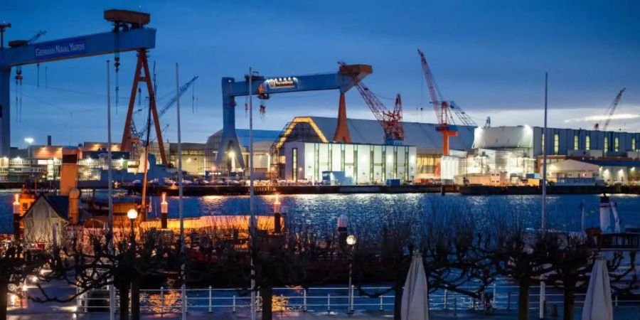 Das beleuchtete Werftgelände von ThyssenKrupp Marine Systems am Ufer der Förde. Foto: Gregor Fischer/dpa
